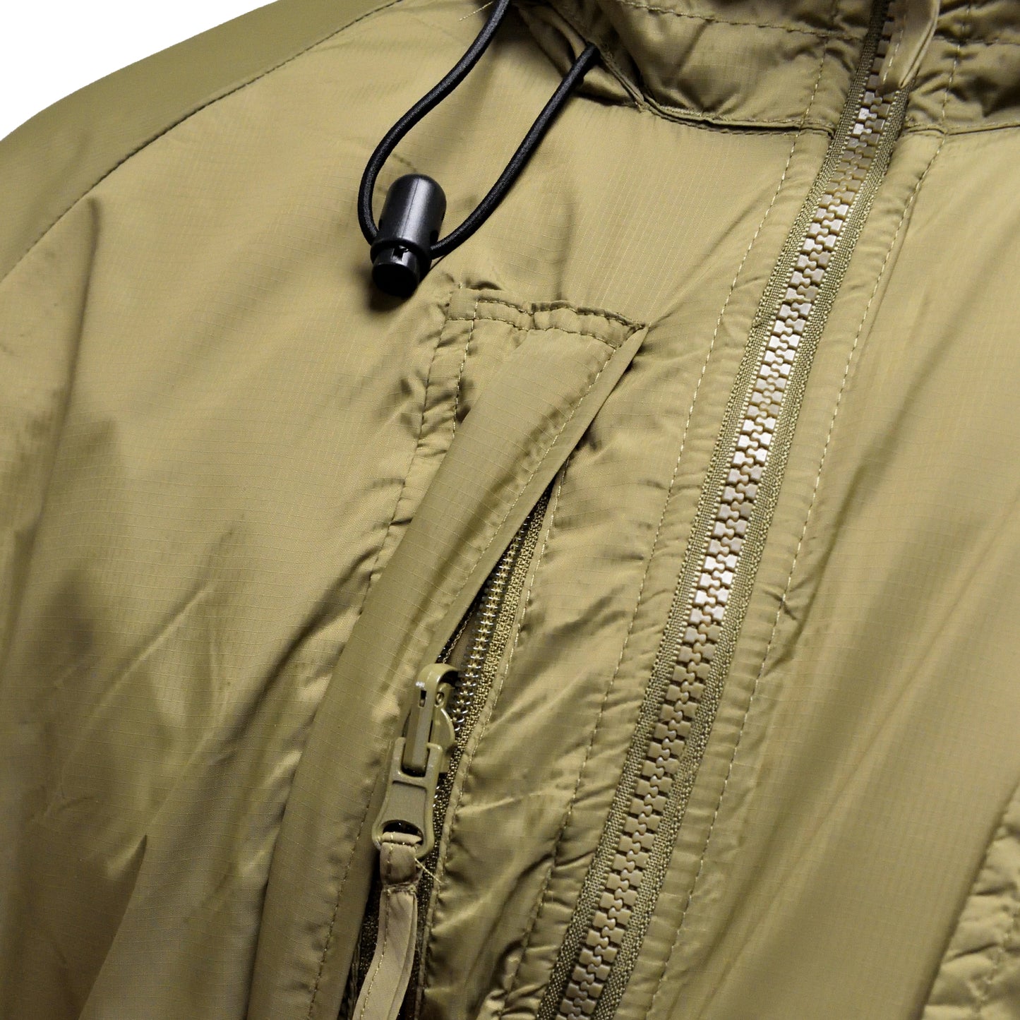 Close-up of zip and pocket details on British Army Thermal Jacket with Integral Stuff Bag in PCS Olive.