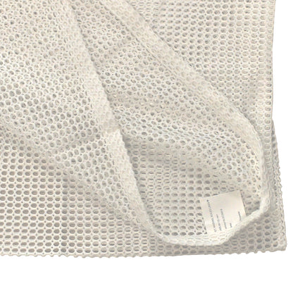 Close-up of stitching and mesh weave on white net bag for soiled linen.